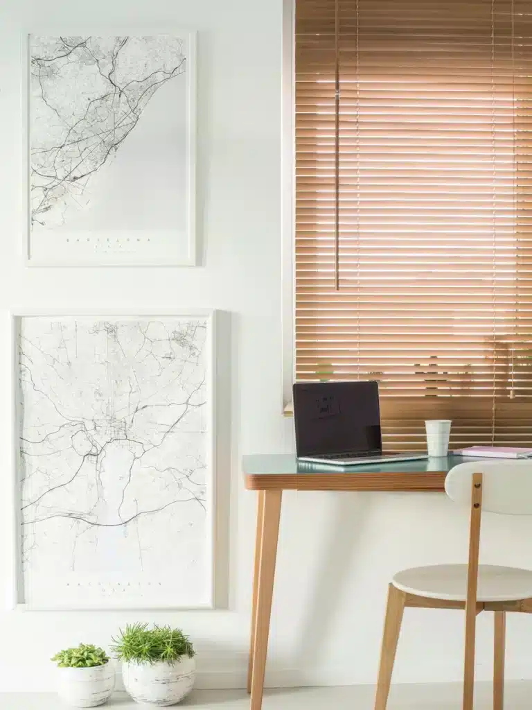 Bureau minimaliste éclairé avec des stores en bois filtrant la lumière, créant une ambiance chaleureuse et fonctionnelle.